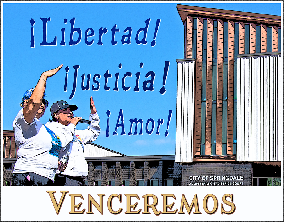 A poster with the words Libertad Justicia and Amor in the sky above the City of Springdale Arkansas civic building with two speakers from Venceremos during a protest march on 31 March 2025